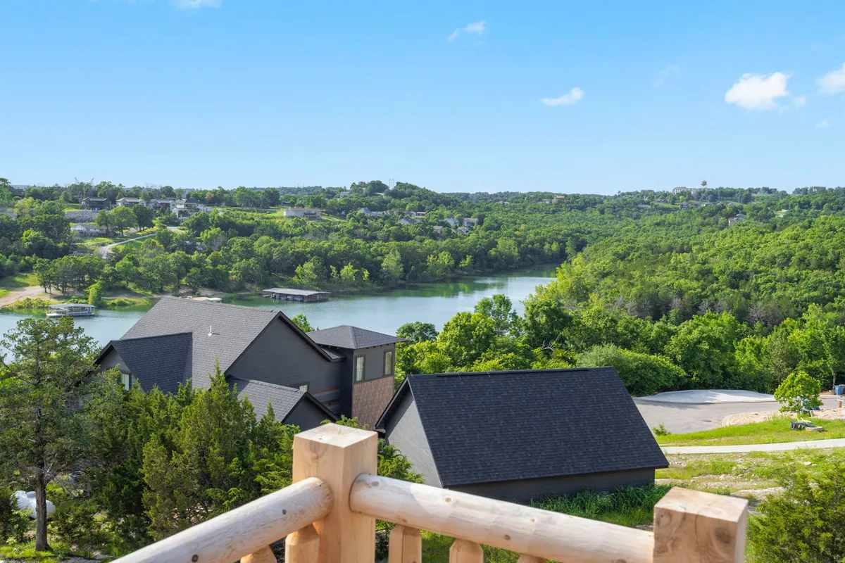 This scenic view features Table Rock Lake bordered by lush green landscape and modern homes. The tranquil lake is ideal for fishing, boating, or simply relaxing by the water, and the perspective highlights easy access to nature and outdoor adventures.