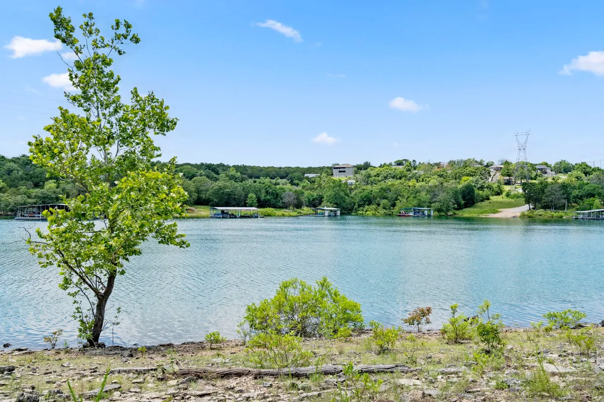 A panoramic view of calm waters surrounded by lush greenery and a distant shoreline. The scene exudes peace and natural beauty, ideal for lakeside strolls or quiet picnics as described in the narrative.